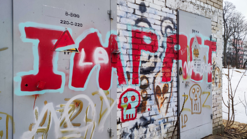 Граффити на металлических дверях кирпичного здания