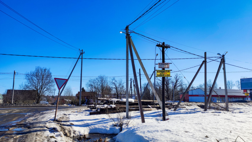 Перекрёсток с дорожным знаком и опорами ЛЭП зимой
