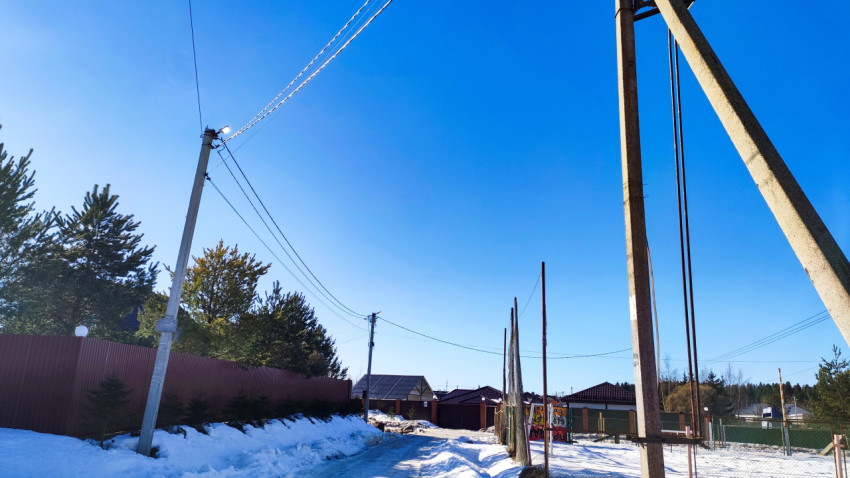 Участок улицы с опорами воздушной линии и частной застройкой