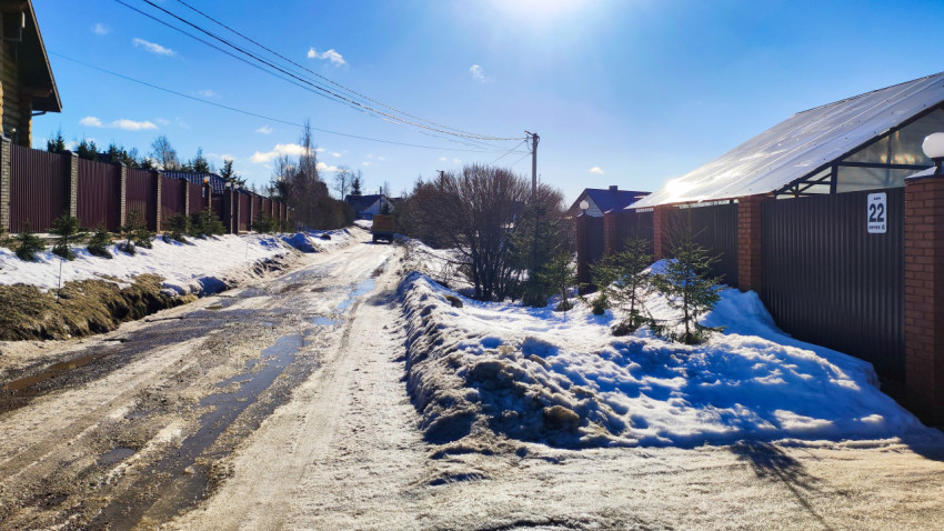 Просёлочная дорога с линией электропередачи вдоль частных домов