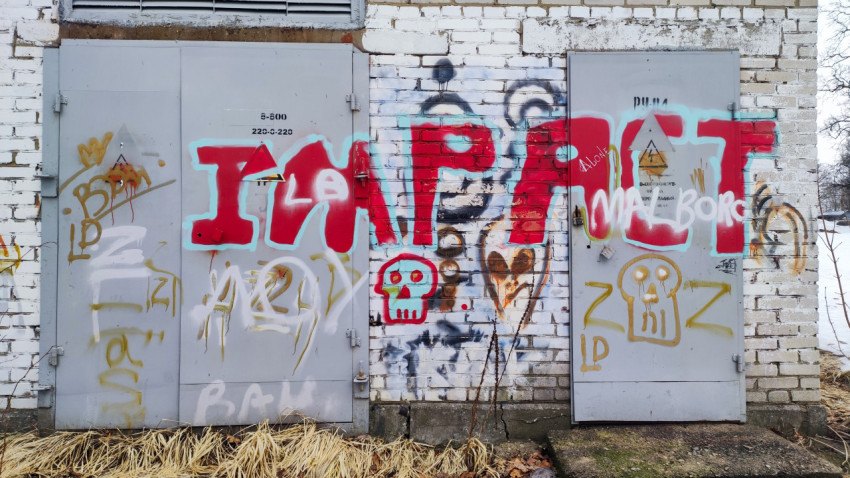 Фрагмент стены с надписями и уличным искусством