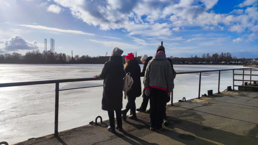 Люди на набережной у замерзшей акватории