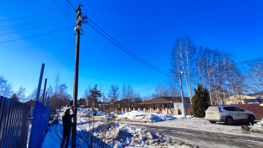 Улица с припаркованным автомобилем и опорой электросети