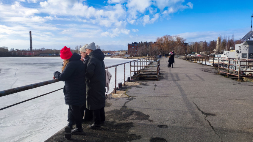 Городская набережная с группой людей у льда