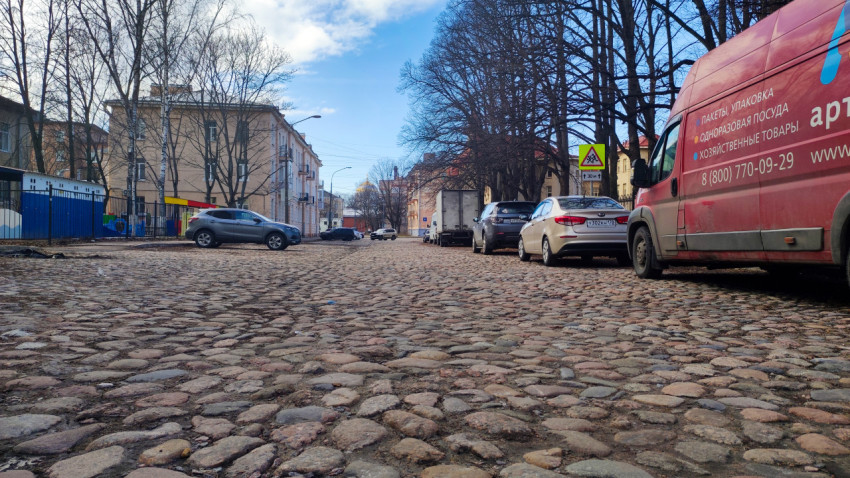 Брусчатая улица с автомобилями в историческом районе