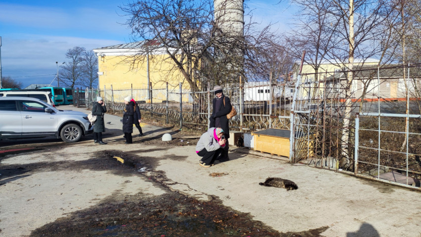 Люди у старого здания и промышленной трубы