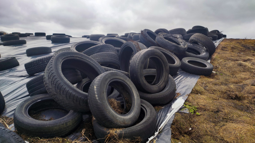 Груды старых автомобильных шин на силосном хранилище