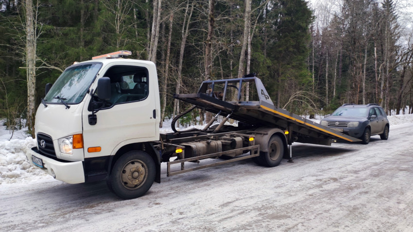 Эвакуатор и внедорожник на зимней дороге