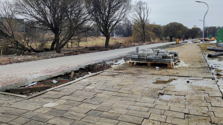 Разрушенный тротуар и строительные материалы в парке