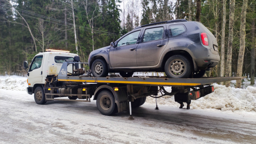 Внедорожник Renault Duster на платформе эвакуатора зимой