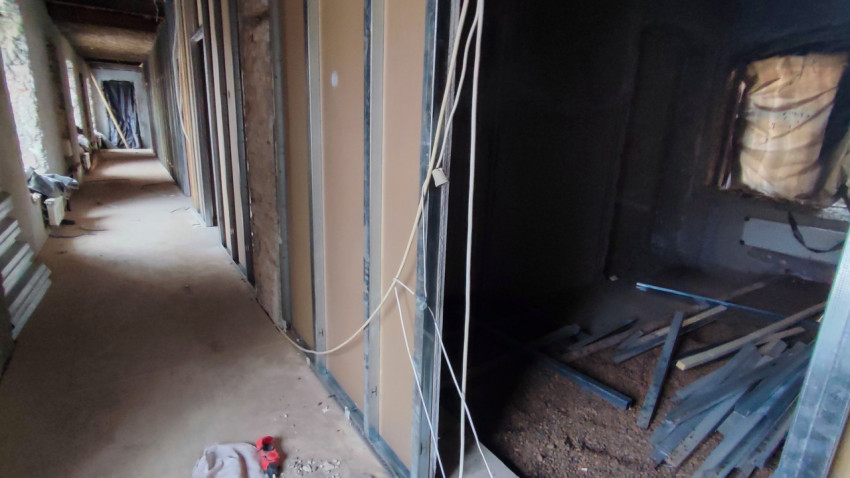 Коридор с металлическими стойками и частично возведёнными перегородками