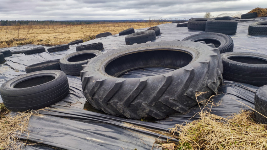 Тракторная шина и автомобильные покрышки на силосном укрытии