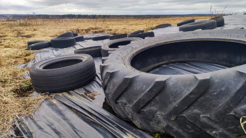 Крупный план тракторной шины на укрытом силосе