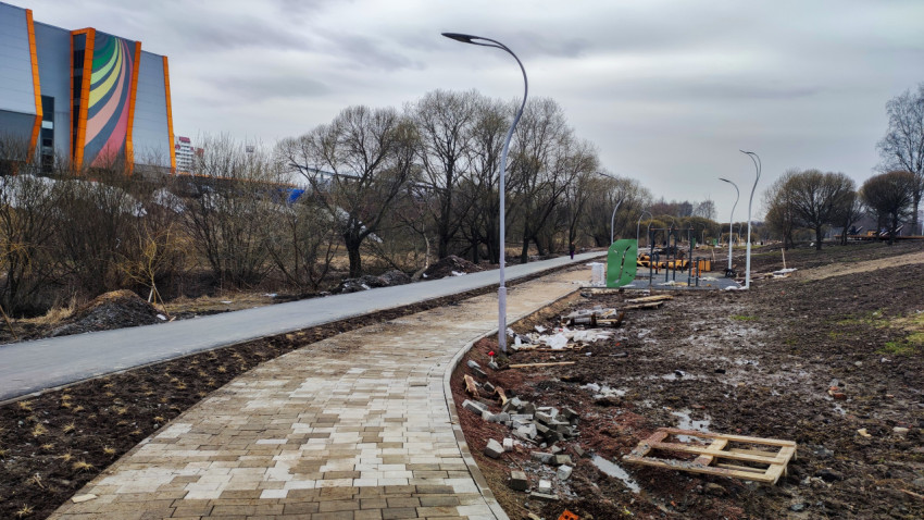 Пешеходная дорожка в новом парке с современными фонарями