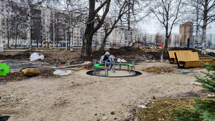 Детская карусель и скамейки на стадии благоустройства парка