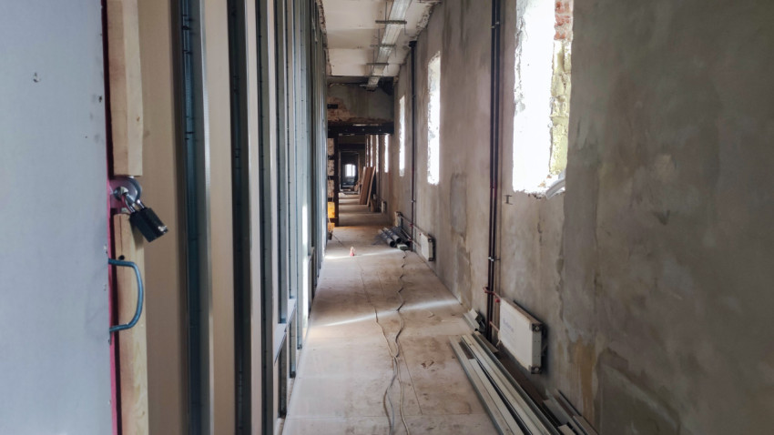 Длинный коридор здания на стадии реконструкции