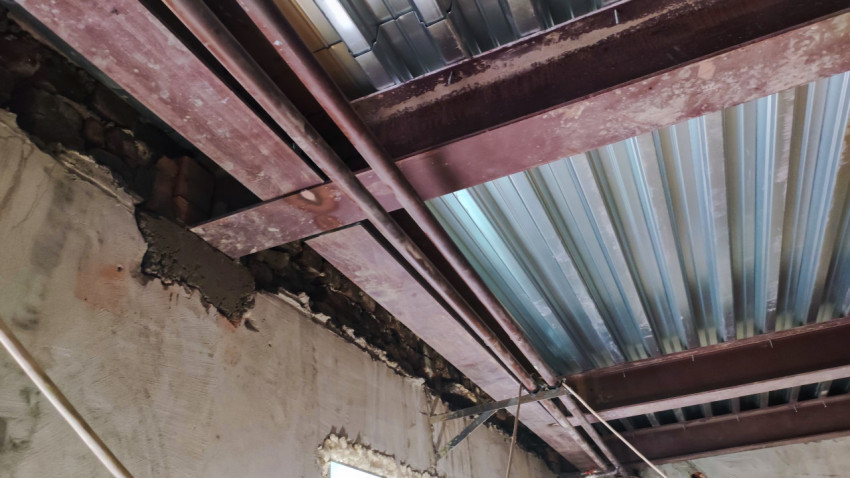 Металлические балки и гофрированные перекрытия под потолком здания