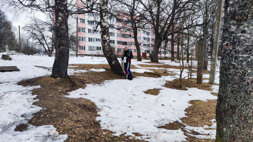 Человек с измерительным оборудованием у деревьев зимой