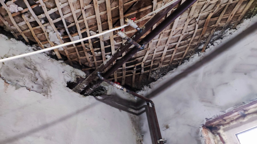 Инженерные трубы под потолком с деревянной дранкой