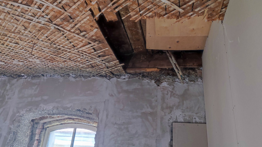 Потолок старого здания с частично демонтированной дранкой