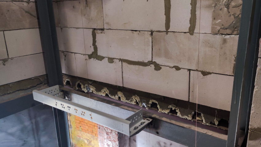 Кирпичная и блочная стена с металлическими элементами в строящемся здании