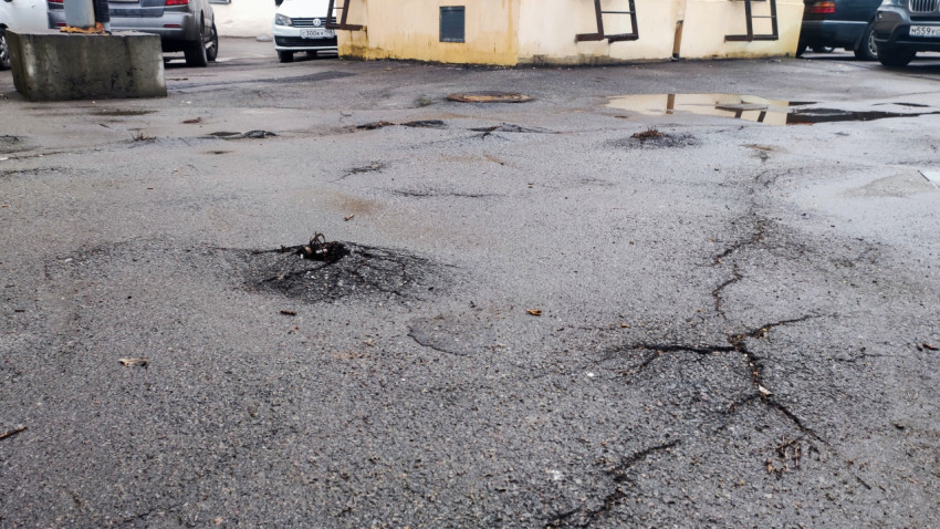 Повреждённое асфальтовое покрытие во дворе