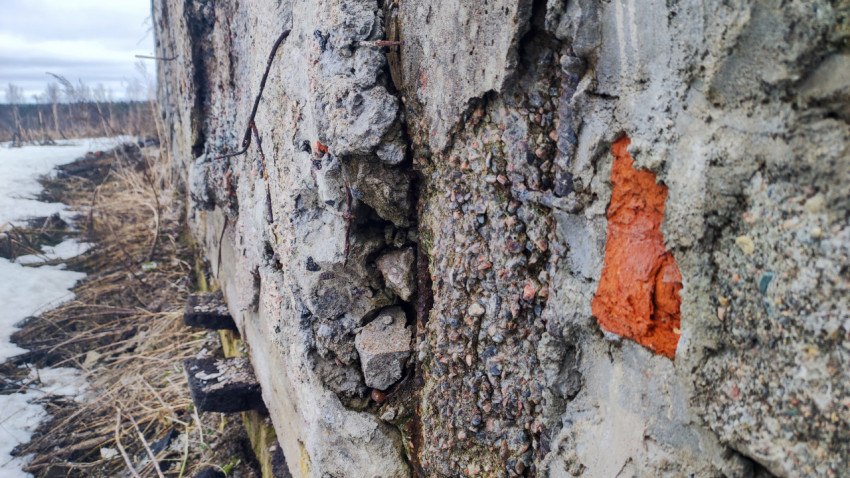 Трещины и кирпичная вставка в старой бетонной стене