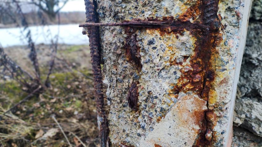 Коррозия арматуры в старом бетонном столбе на заброшенной территории