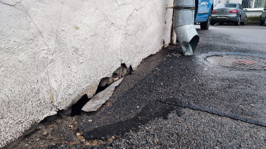 Повреждение фасада здания возле водосточной трубы