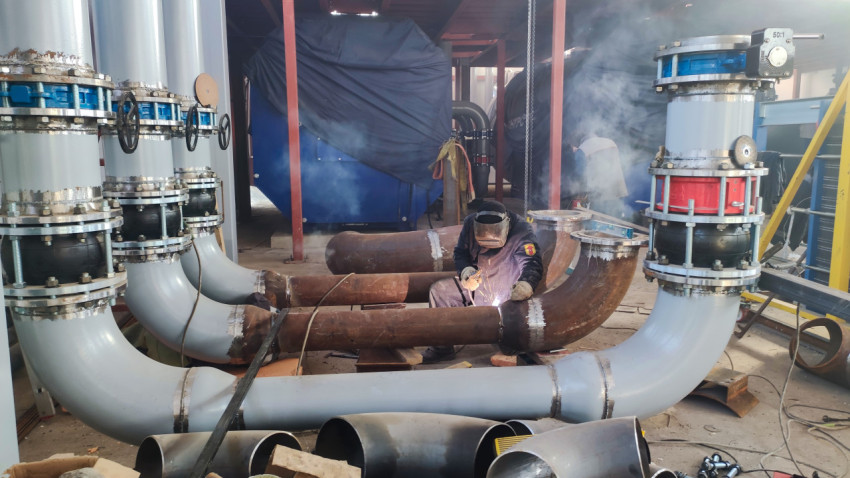 Процесс сварки трубопровода в промышленном помещении