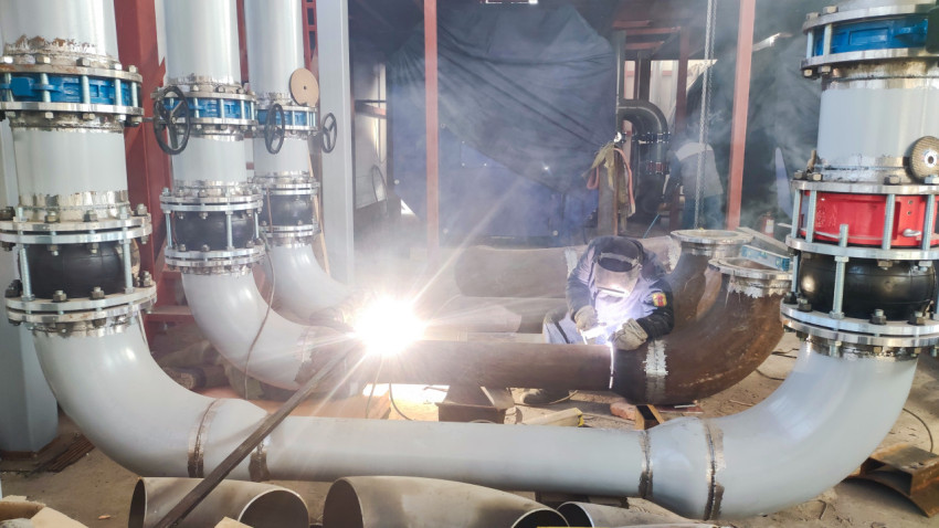 Электродуговая сварка трубопровода в промышленном помещении