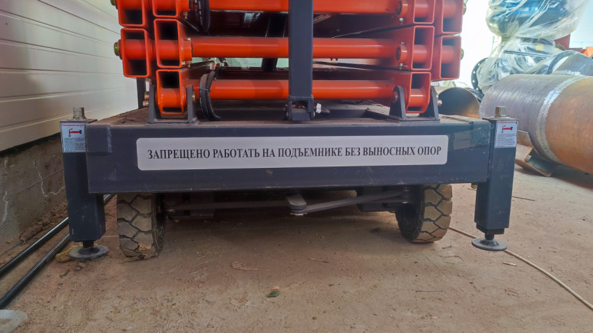 Гидравлический подъемник с выносными опорами на производственной площадке