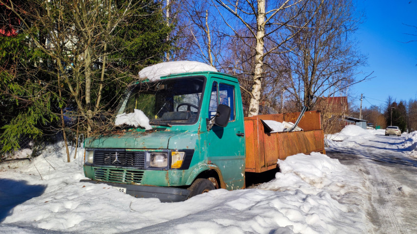 Фронтальный вид старого грузовика у обочины зимой