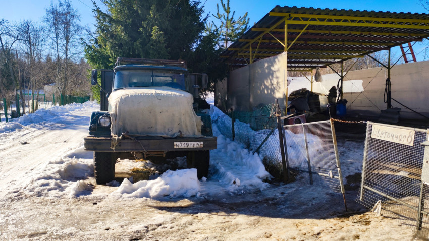 Старинный грузовик у хозяйственного навеса зимой