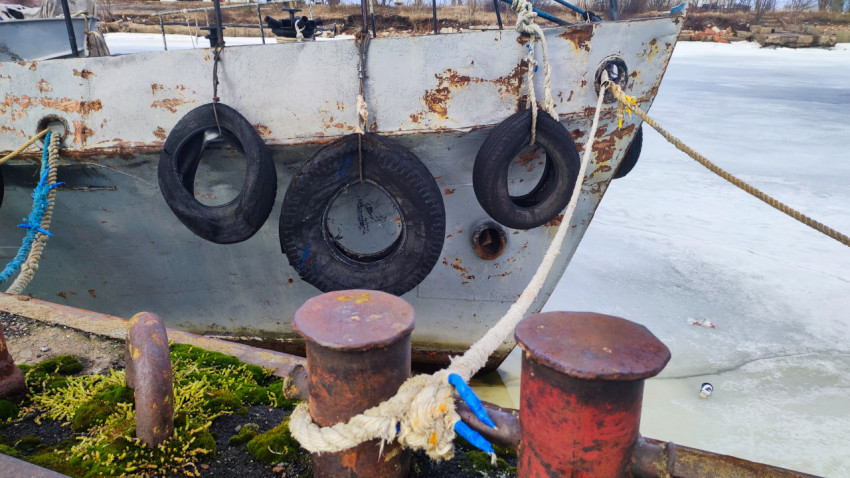 Нос старого судна с отбойниками и ржавчиной у пирса