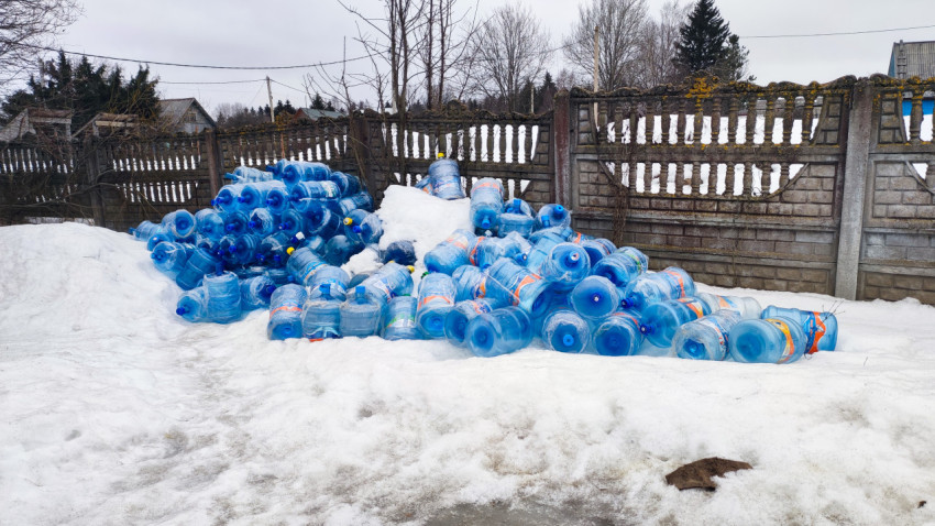 Пустые пластиковые бутылки на снегу возле бетонного ограждения