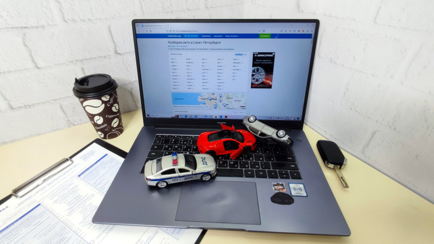 Ноутбук Huawei с моделями автомобилей и ключом на столе