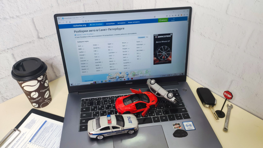 Рабочее место с ноутбуком Huawei и игрушечными автомобилями