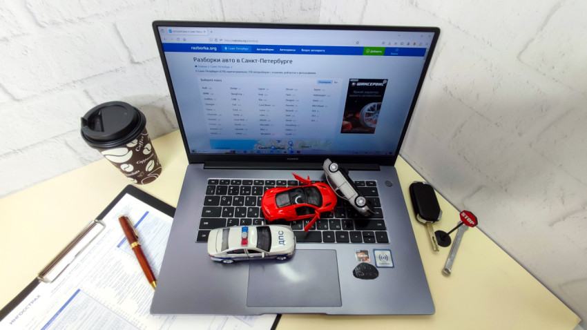 Рабочее место с ноутбуком Huawei и моделями автомобилей