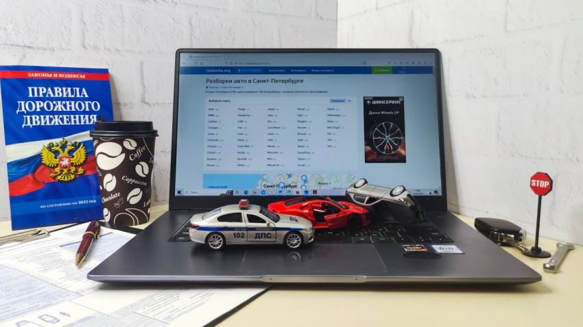 Ноутбук с модельными машинами и книгой ПДД на столе