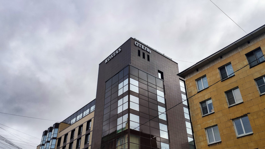 Фасад современного отеля KOSTAS на фоне пасмурного неба
