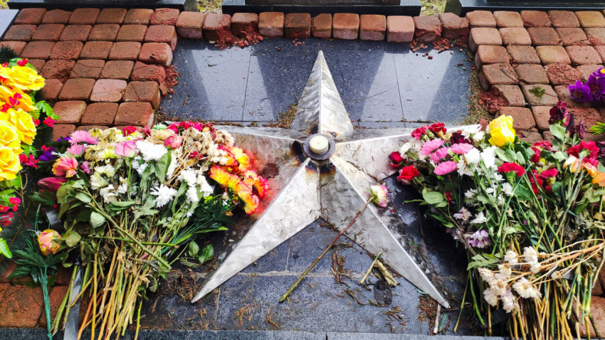 Центральная звезда мемориала, украшенная цветами в память о погибших