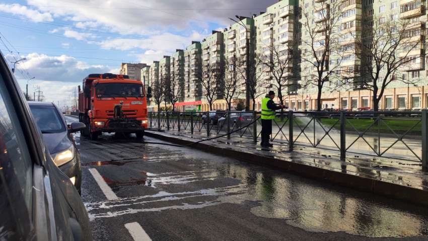 Коммунальный рабочий очищает ограждение вдоль городской проезжей части