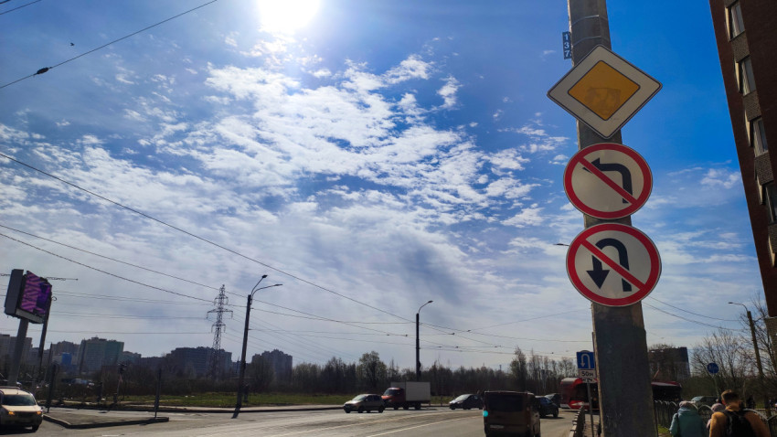 Дорожные знаки на фоне городской улицы и неба