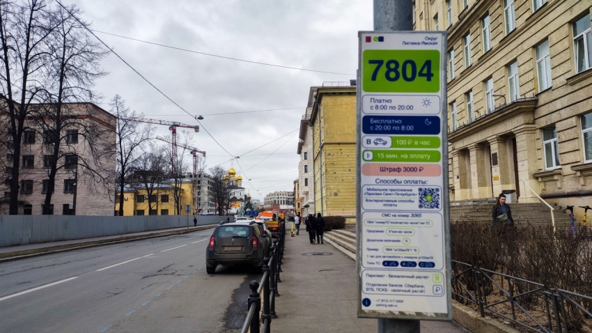 Знак парковочной зоны 7804 рядом с жилыми зданиями и проезжей частью