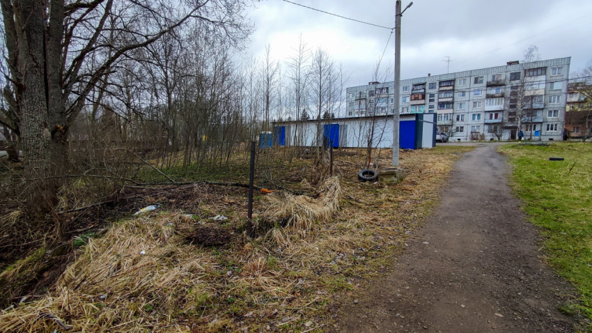 Грунтовая тропа у гаражных боксов на фоне жилого дома