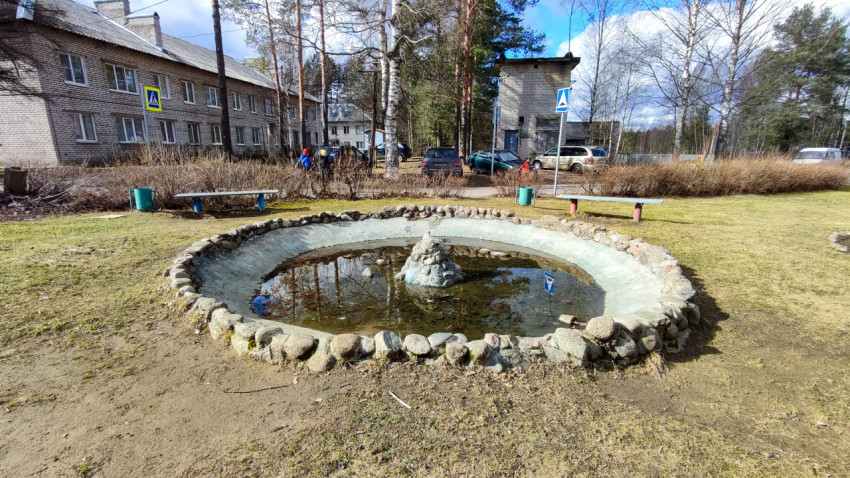 Небольшой каменный фонтан во дворе жилых домов