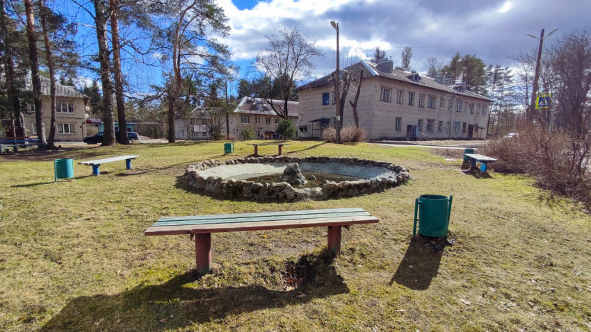 Площадь с небольшим фонтаном и скамейками среди жилых домов