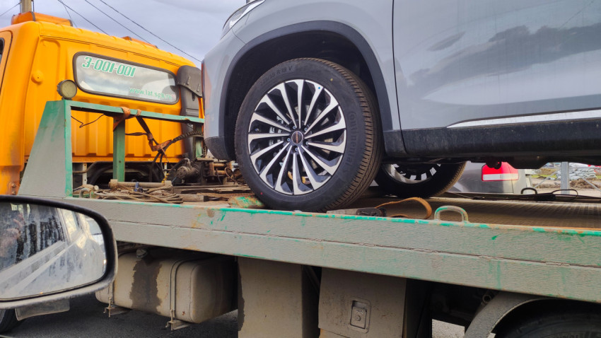 Крупный план переднего колеса автомобиля на эвакуаторе