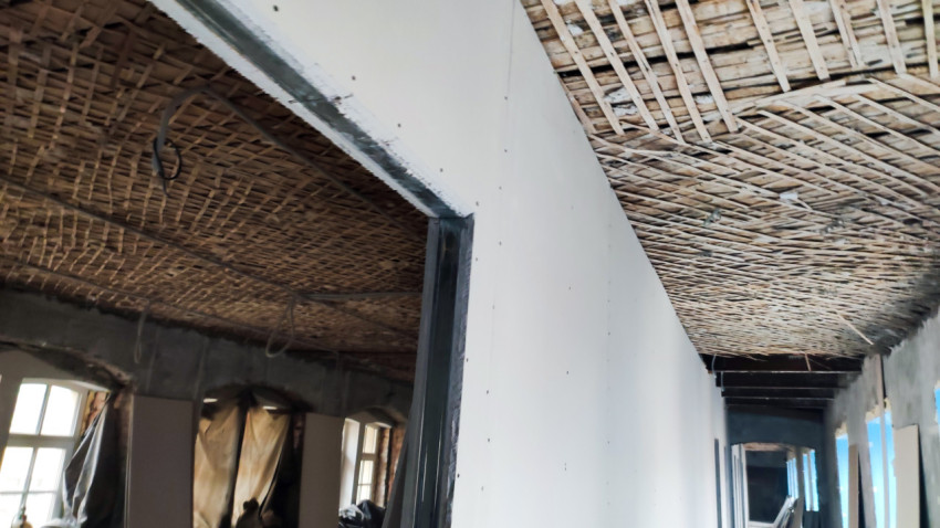 Потолок с деревянной дранкой и коридор в процессе черновой отделки